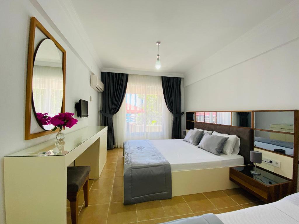 a hotel room with a bed and a mirror at Melisa Hotel in Bozburun