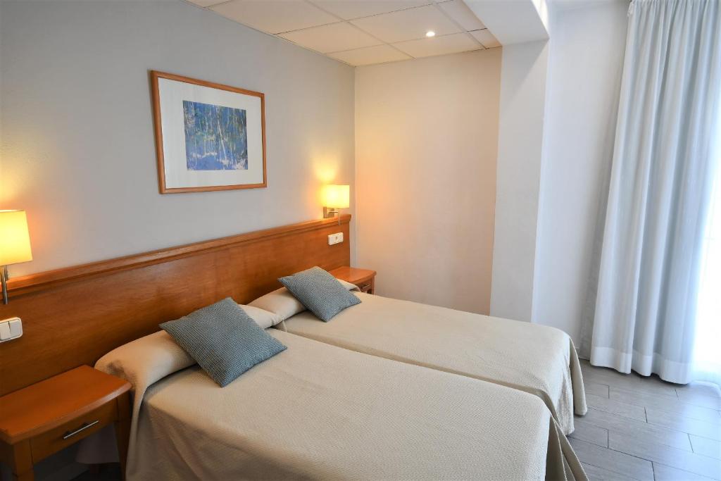 A bed or beds in a room at Hostal Mallorca