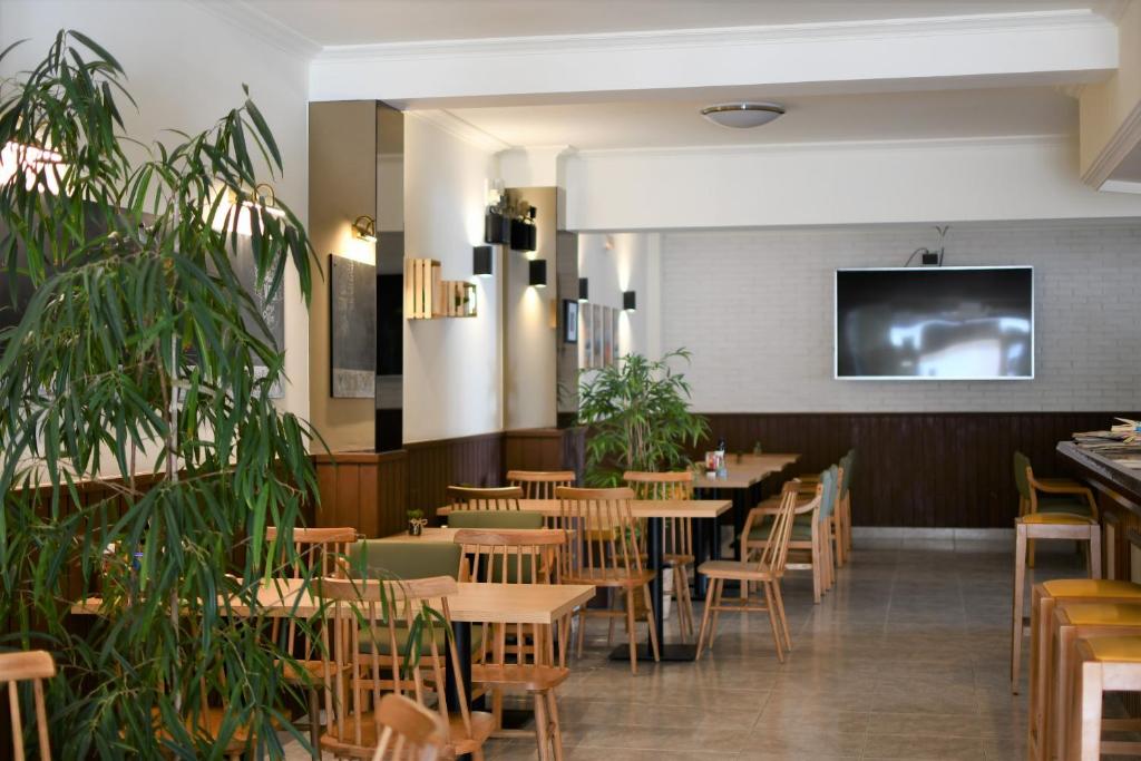 a restaurant with wooden tables and chairs and a flat screen tv at Hostal Mallorca in San Antonio