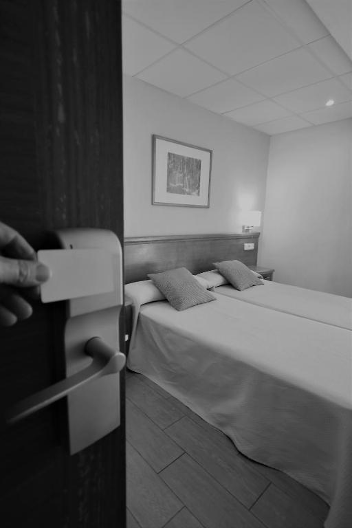 A bed or beds in a room at Hostal Mallorca