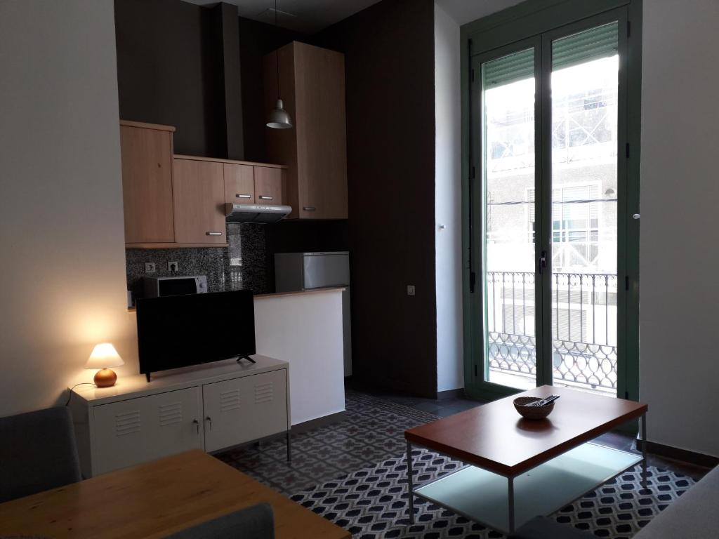 a kitchen with a table and a refrigerator at Apartamento Confortable En Ciudad in Tarragona