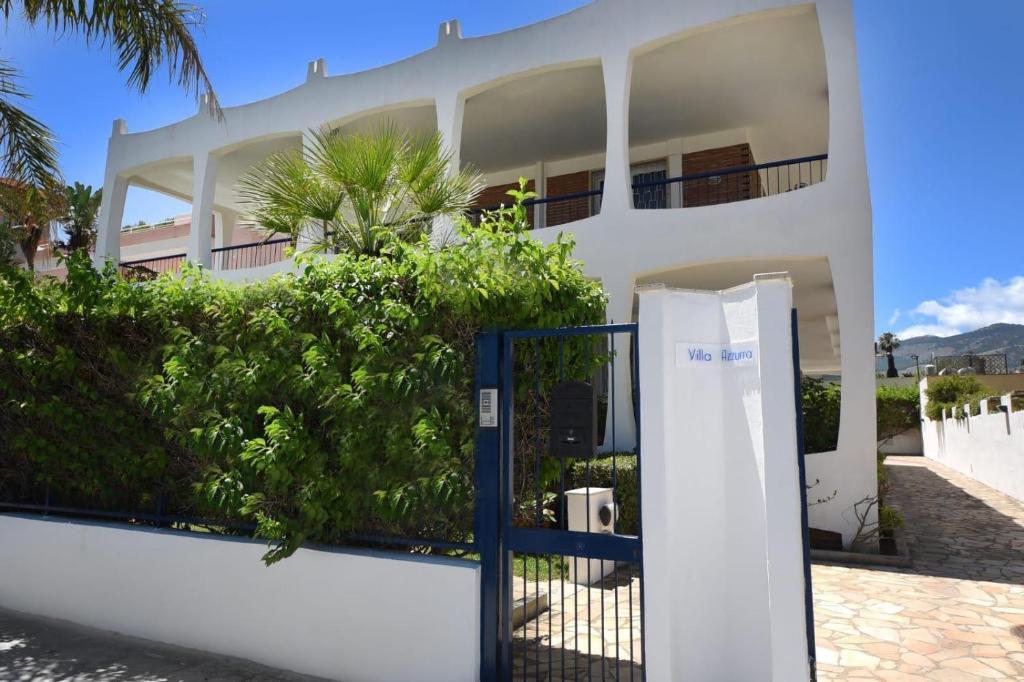 ein weißes Haus mit einem Tor davor in der Unterkunft VILLA AZZURRA beachfront Mondello - Palermo in Palermo