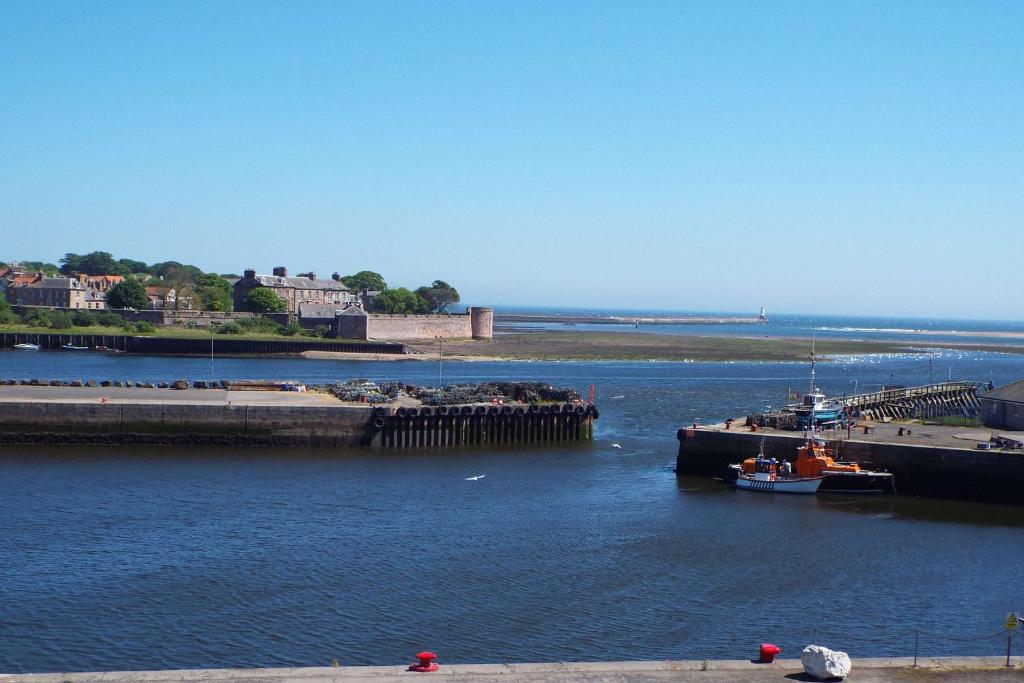 a boat is docked at a dock in the water at 8 Mill Wharf in Berwick-Upon-Tweed