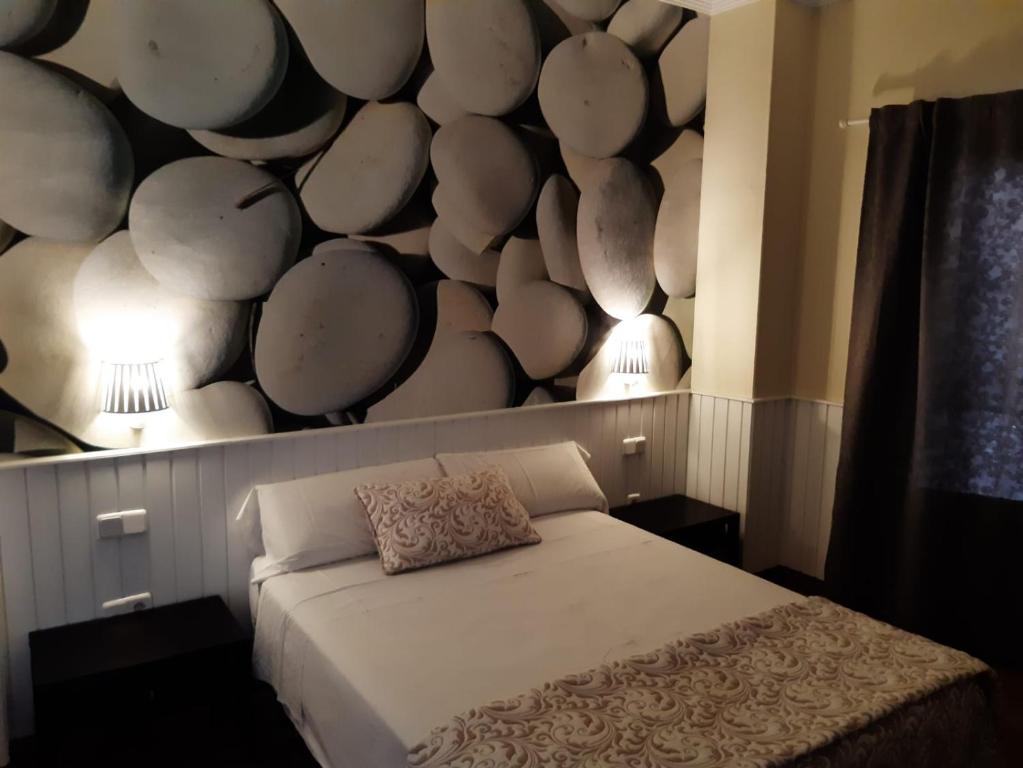 a bedroom with a white bed with a wall covered in circles at Hotel Marisma Sancti Petri in Chiclana de la Frontera