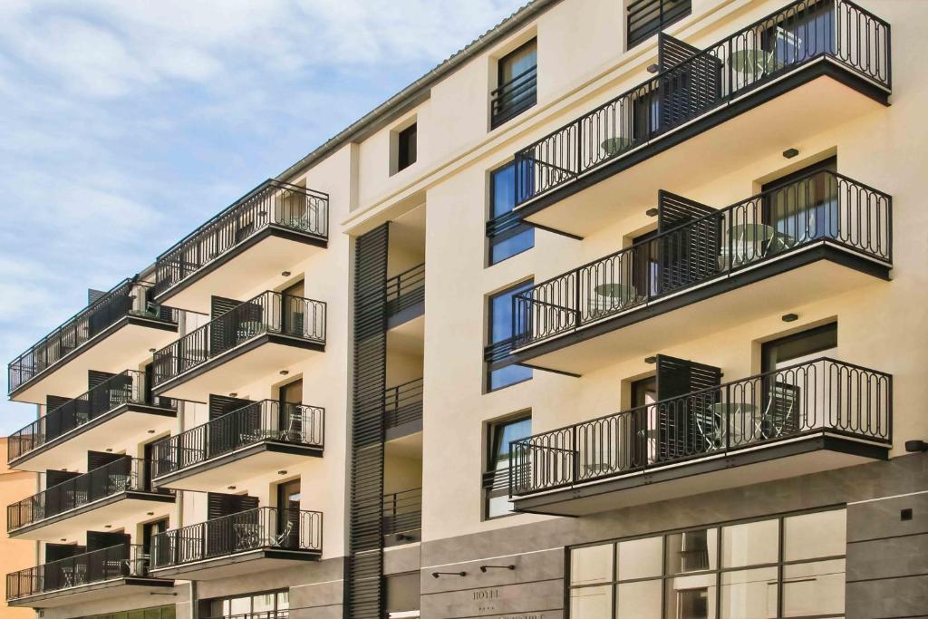 an apartment building with balconies on the side of it at Hôtel La Villa Port d'Antibes & Spa in Antibes