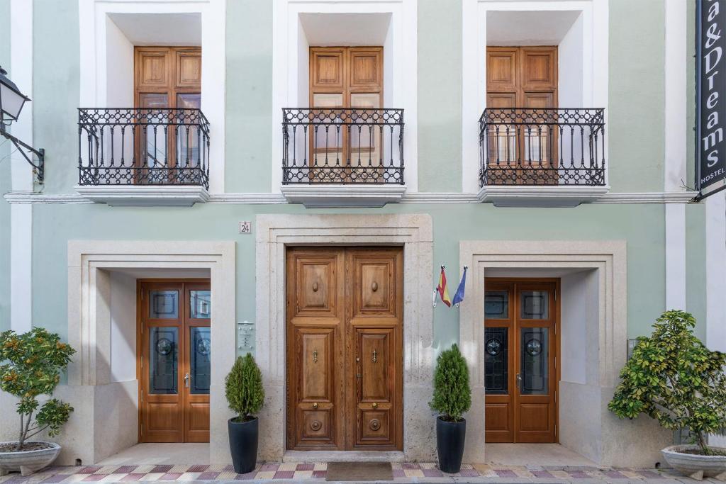 a facade of a building with wooden doors and balconies at Hostel SEA&DREAMS Calpe in Calpe