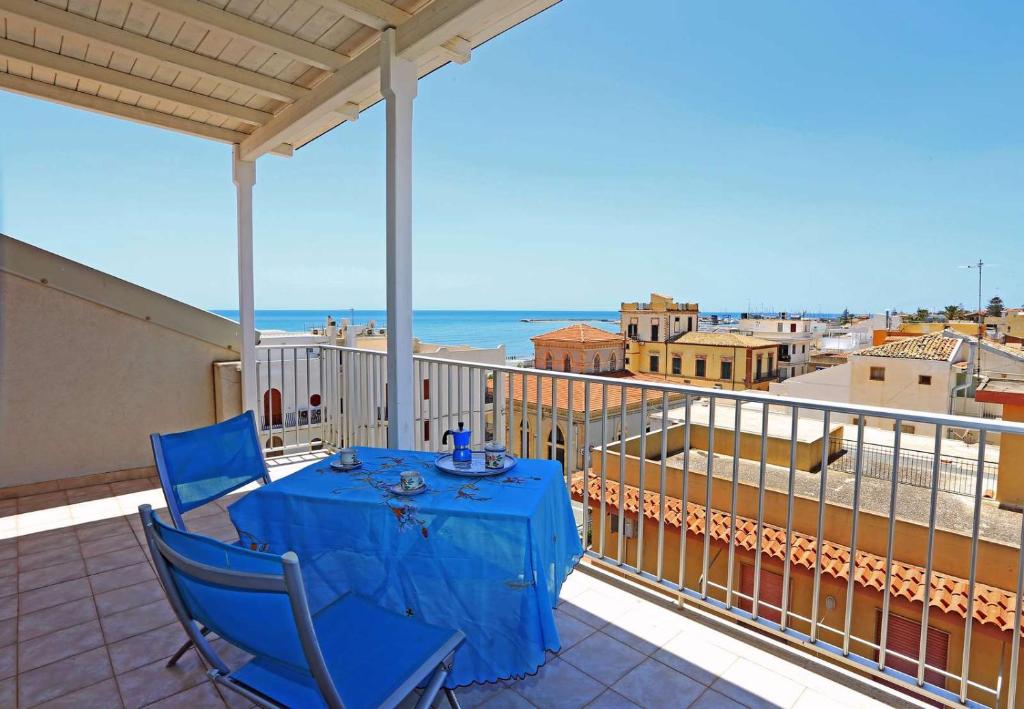 マリーナ・ディ・ラグーザにあるAppartamento Sciroccoの海を望むバルコニー(青いテーブル、椅子付)