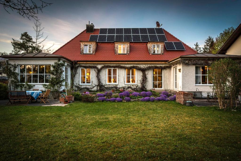 una casa con paneles solares en el techo en München- Pullach, Wohnen im Grünen, en Pullach im Isartal