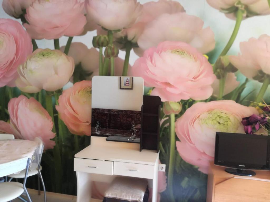 a wall of pink flowers with a computer on a desk at Krasi Apartments in Perla Complex in Pomorie
