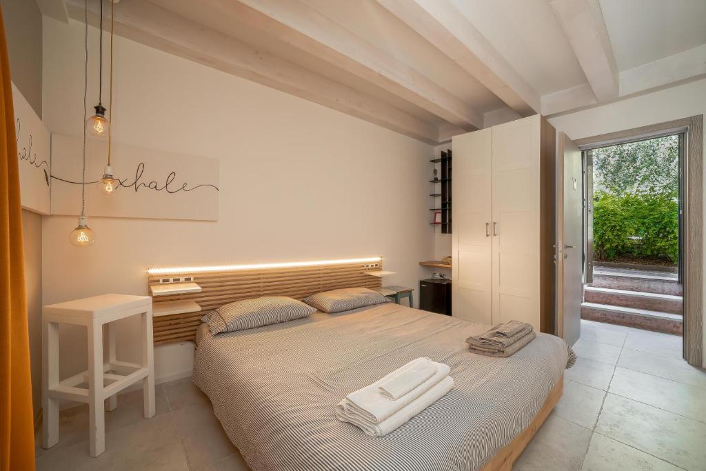 a bedroom with a large bed with two towels on it at Le Scuderie B&B in Arco