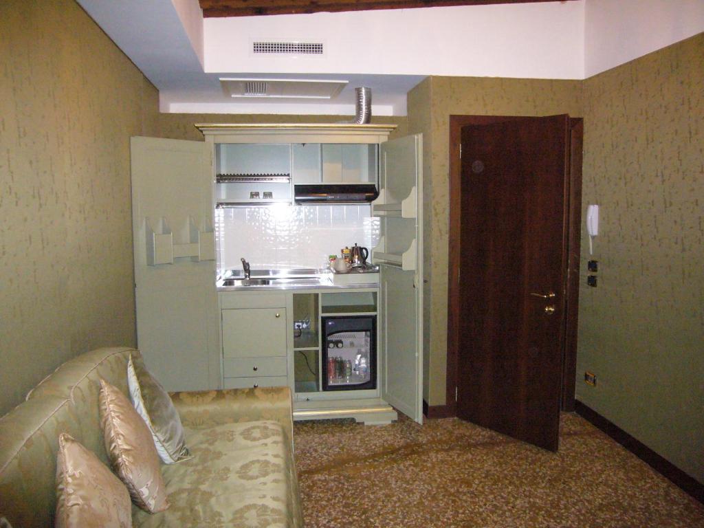 a small kitchen with a television and a refrigerator at Hotel Al Ponte Mocenigo in Venice