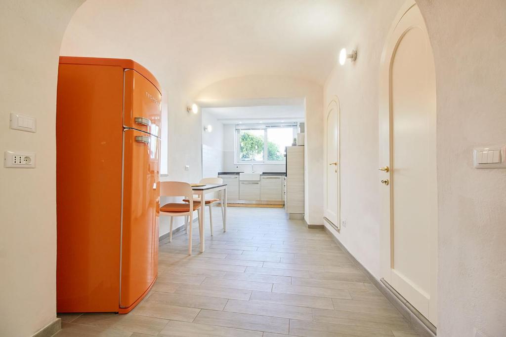 einen orangenen Kühlschrank im Flur mit einem Tisch in der Unterkunft Via Garibaldi in Orco Feglino