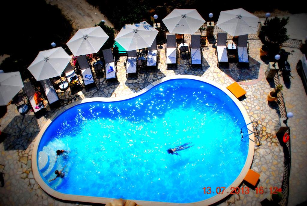 an overhead view of a large swimming pool with umbrellas at Villa Dorita Luxury Apartments in Parga