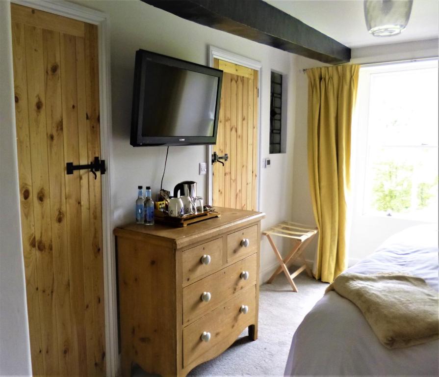 a bedroom with a bed and a dresser with a television on it at The Burrows Bed and Breakfast in Pembroke