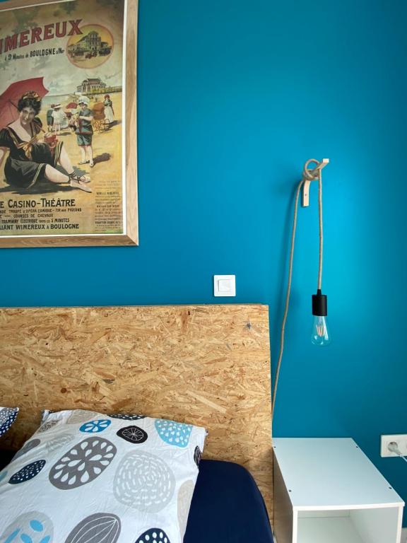 um quarto com uma cama de dossel na parede em Le Réservoir em Wimereux