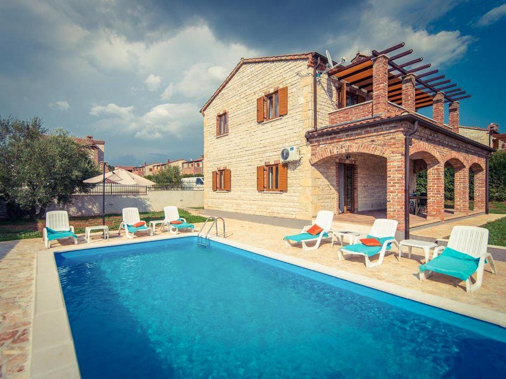 eine Villa mit einem Pool vor einem Haus in der Unterkunft Villa Stella in Svetvinčenat