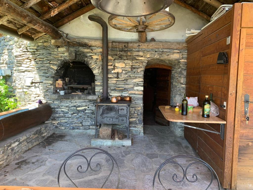 una cocina al aire libre con horno en un edificio de piedra en Chalet Natacha en Anzère