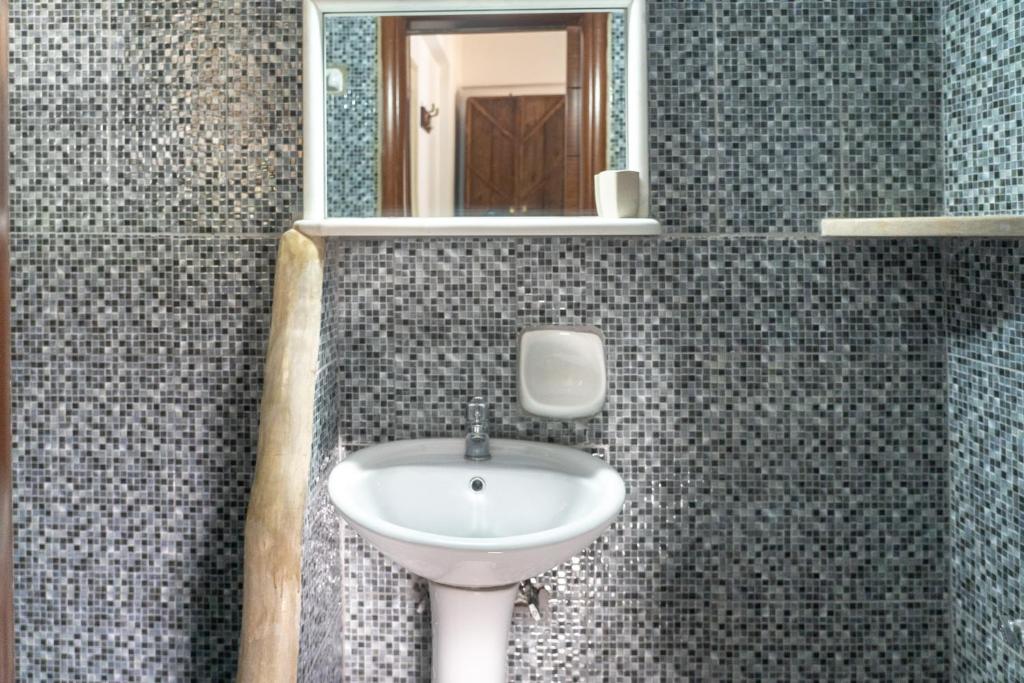 a bathroom with a sink and a mirror at Alexandros by the Beach - Serifos in Livadakia