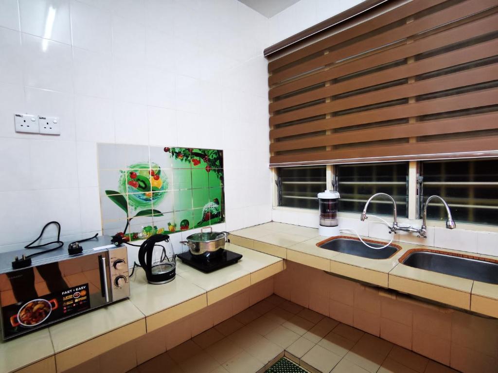eine Küche mit einem Waschbecken und einem Fenster in der Unterkunft Bidor Totoro and One piece animation house in Kampong Kuala Gepal