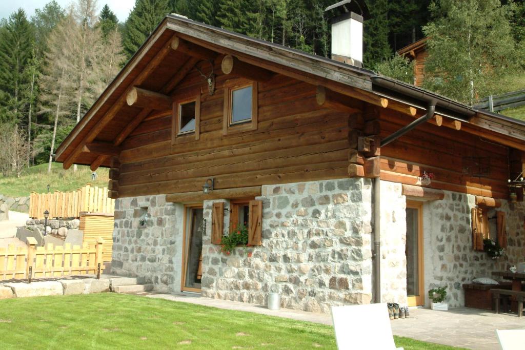 a stone and wood house with a porch at BAITA NONNO GHINO in Bedollo