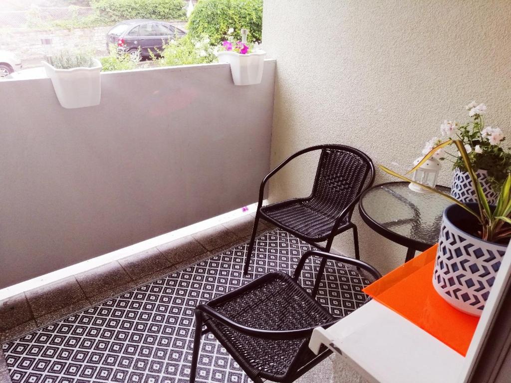 a balcony with chairs and a table and a window at Przyjemna Miejscówka in Gorzów Wielkopolski