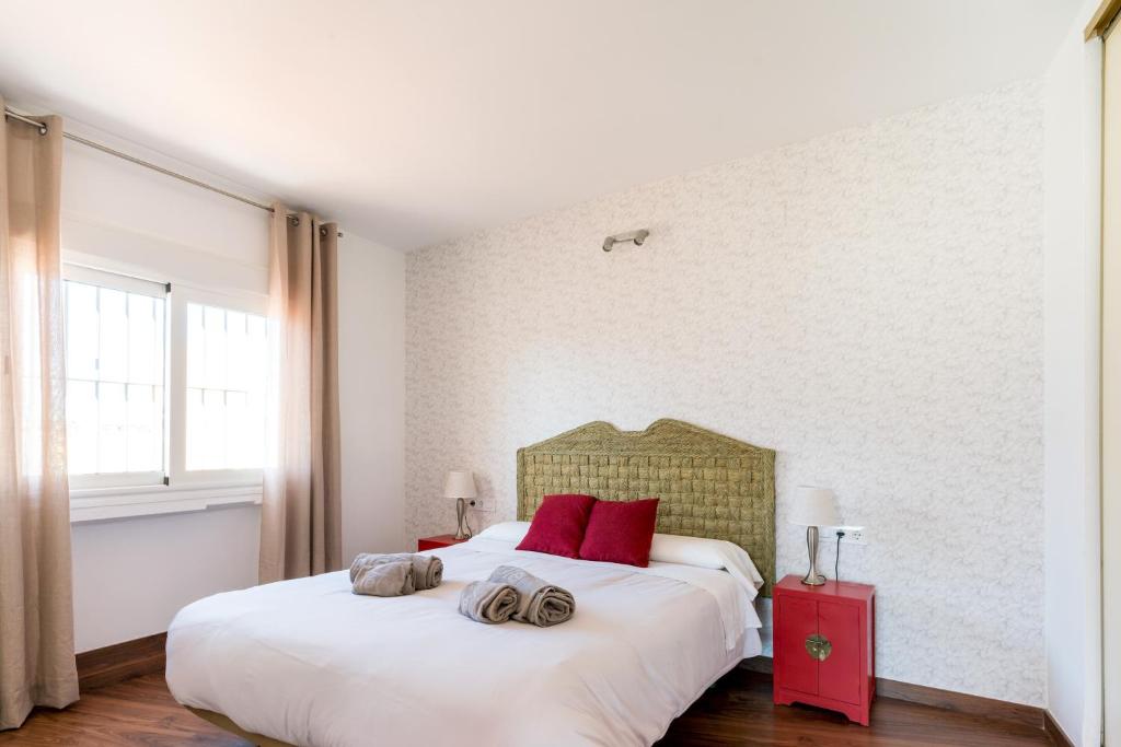 セビリアにあるConstitución Terrazaのベッドルーム(赤い枕の大きな白いベッド付)