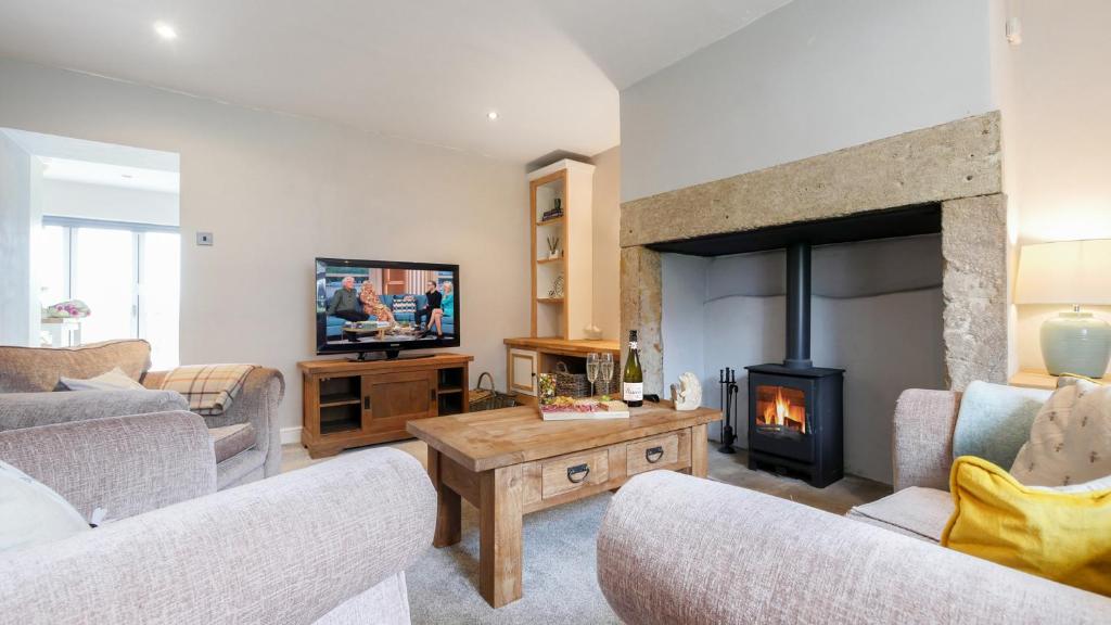 a living room with a couch and a fireplace at Swallowship Cottage in Hexham