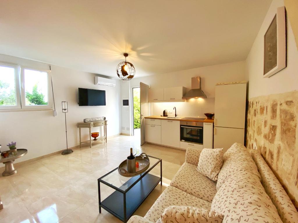 ein Wohnzimmer mit einem Sofa und einer Küche in der Unterkunft MG House with Sea and Garden view in Korakiaí