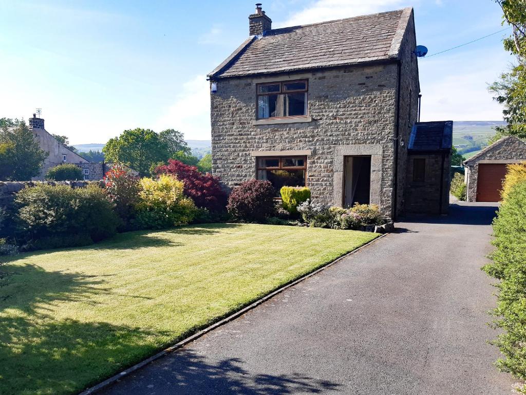 a stone house with a grass yard and a driveway at Westholme in Barnard Castle