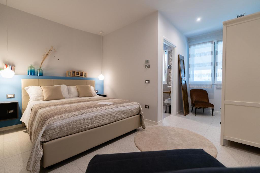 a bedroom with a large bed and a chair at B&B Il Granaio Celeste in Porto Viro