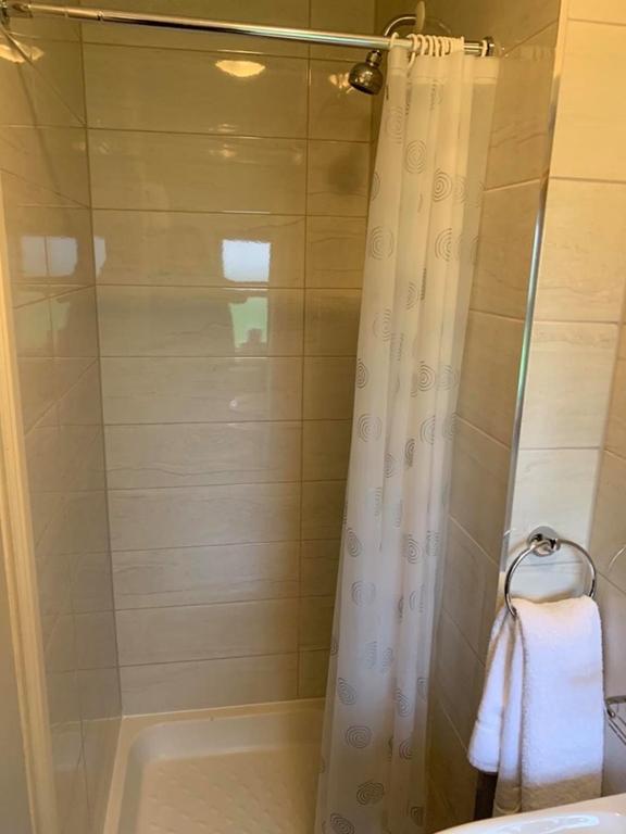 a bathroom with a shower curtain and a bath tub at Amber Cottage in Killarney