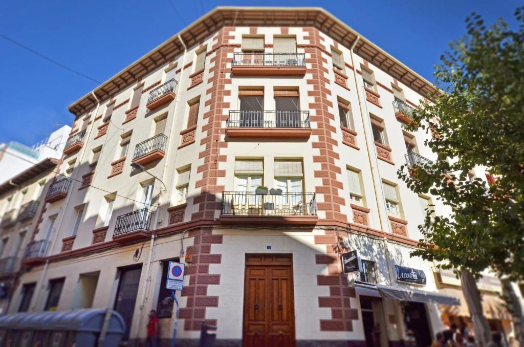 - un grand bâtiment en briques avec une porte et un balcon dans l'établissement Historic apartment by Mercado Central by NRAS, à Alicante