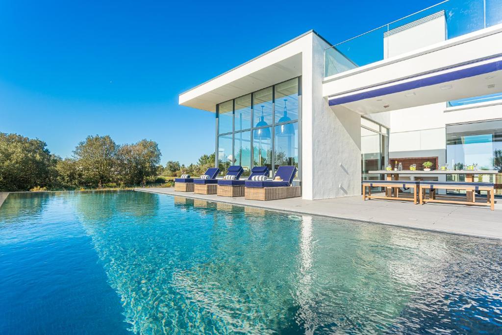 - une vue sur l'extérieur d'une maison avec une piscine dans l'établissement Villa Montchavin, à Quinta do Conde