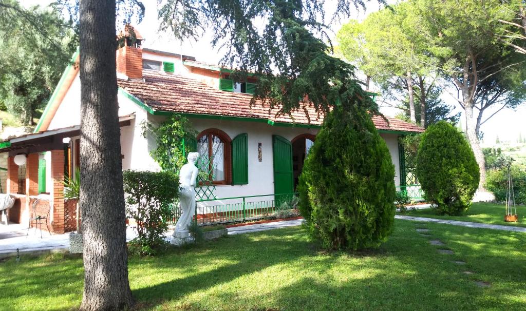uma casa com uma estátua em frente em I Pini House em Magione