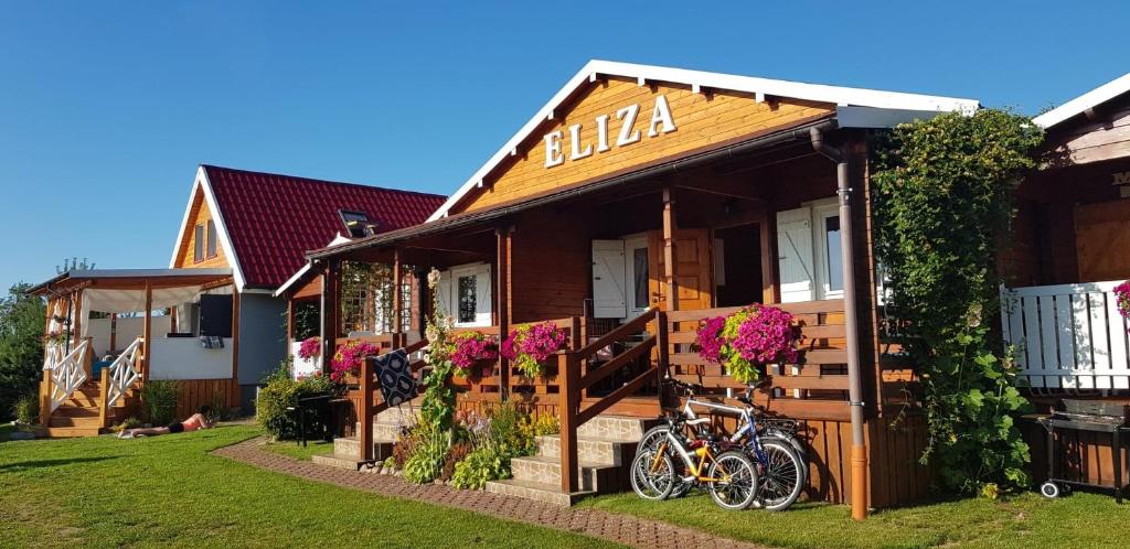 a house with two bikes parked outside of it at Domki letniskowe Eliza in Chłopy