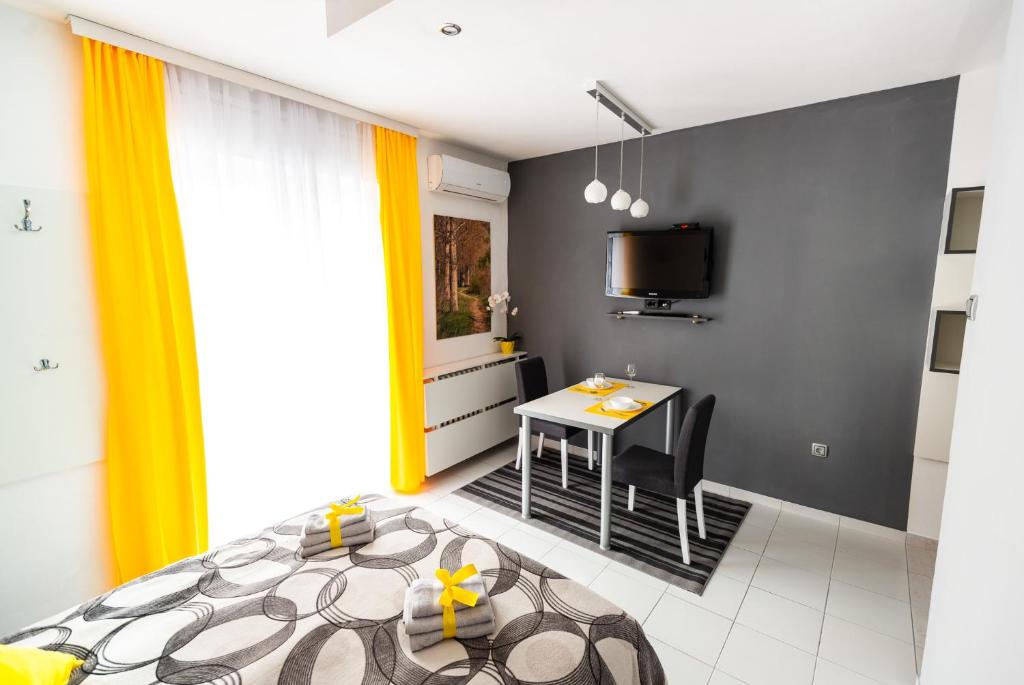 - une chambre avec un lit et une table avec des chaises dans l'établissement BLACK & YELLOW Centrally located studio, à Novi Sad