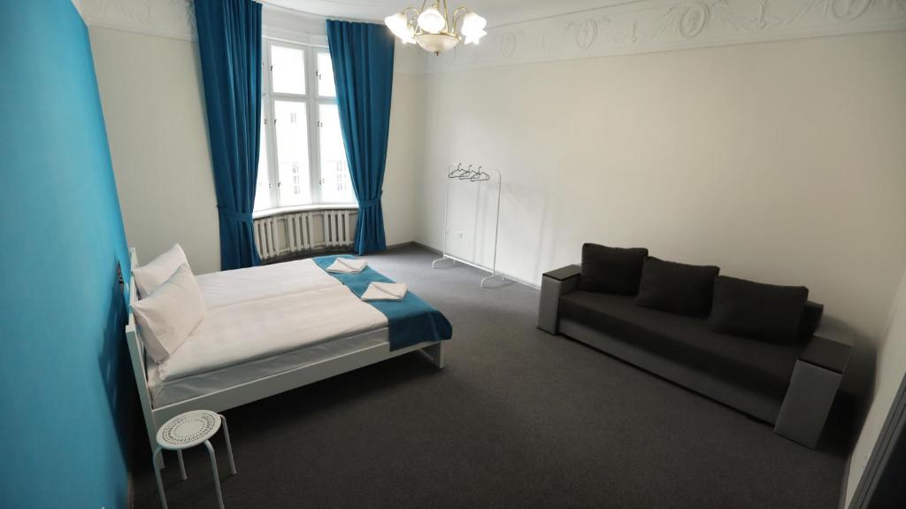 a small bedroom with a bed and a couch at Family Hostel Lviv in Lviv