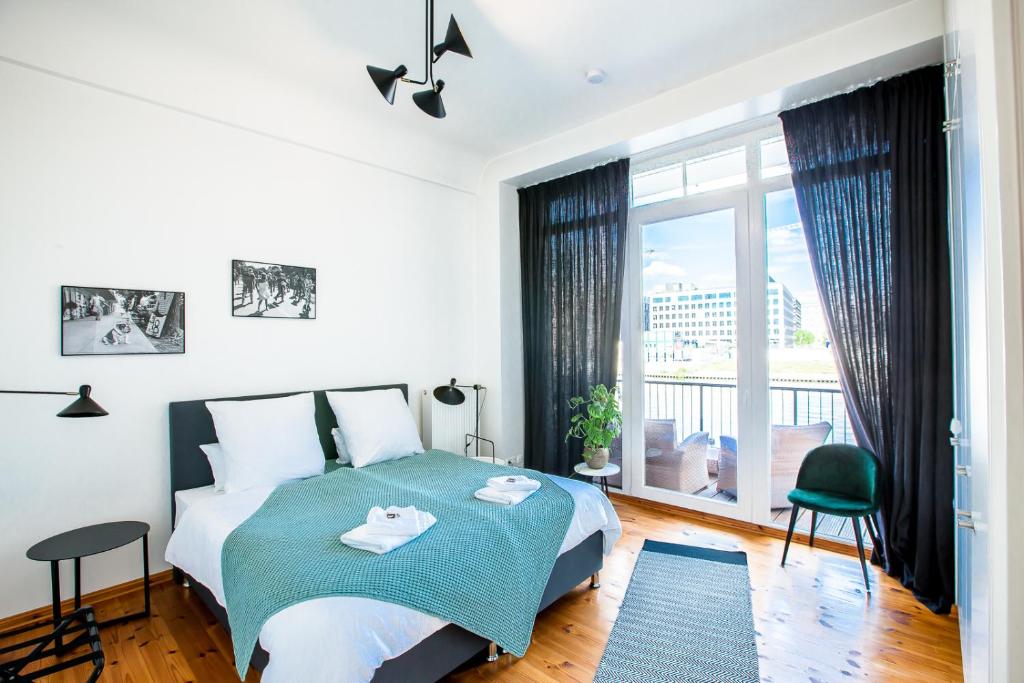 um quarto com uma cama e uma grande janela em Family-friendly Waterfront Loft, 3 Bedrooms, 130 m2 em Berlim