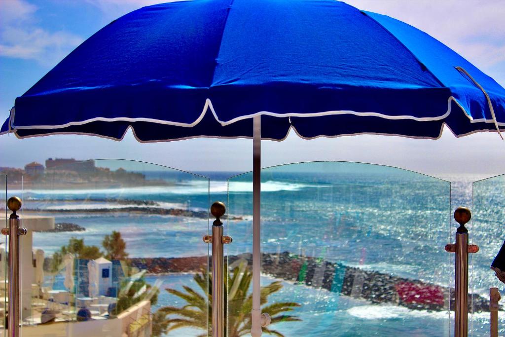 アデへにあるVilla Mar First line Playa Las Americasの海の景色を望む青い傘