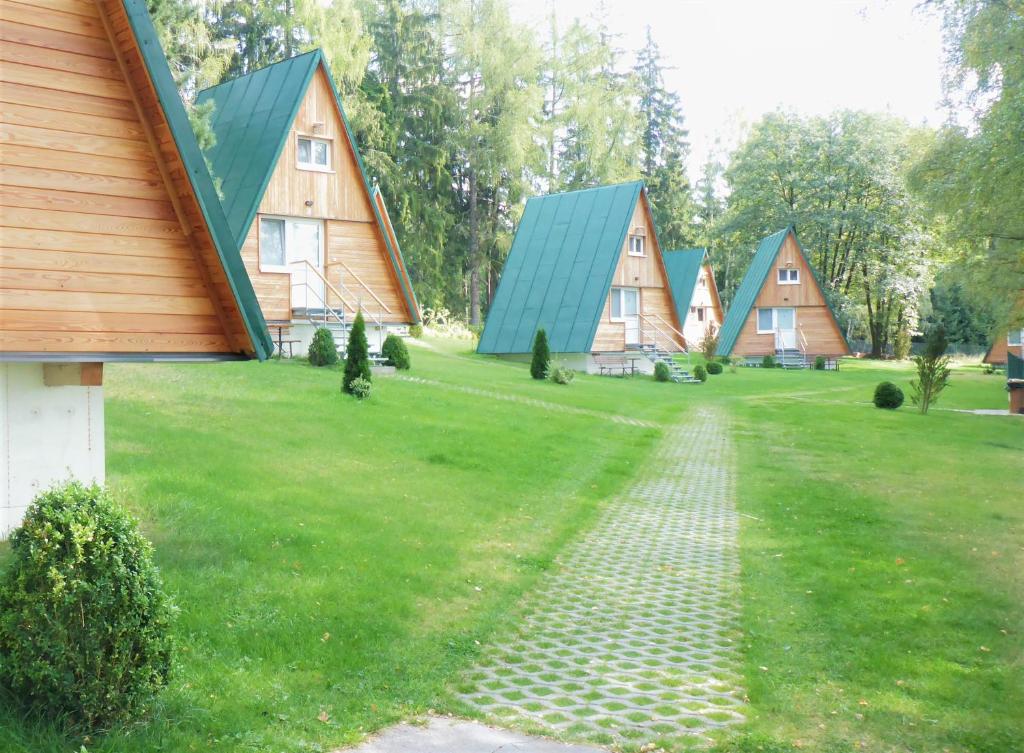 une rangée de maisons avec des toits verts sur une prairie dans l'établissement Chatky Sázava, à Sázava