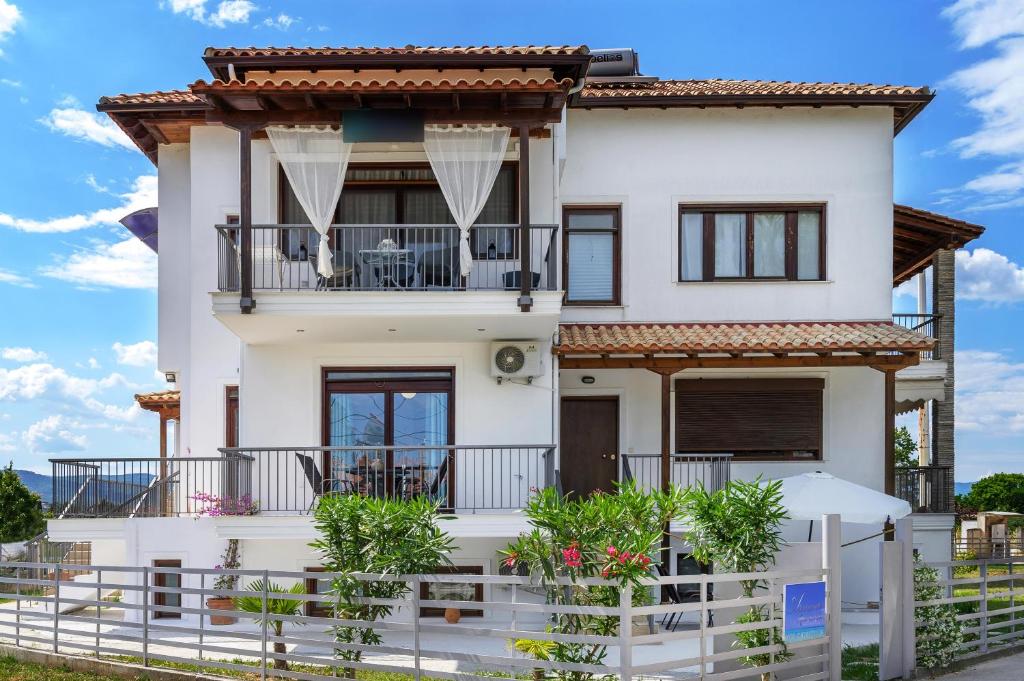 Armenos Elegance Apartments في إيريسوس: بيت أبيض مع شرفة