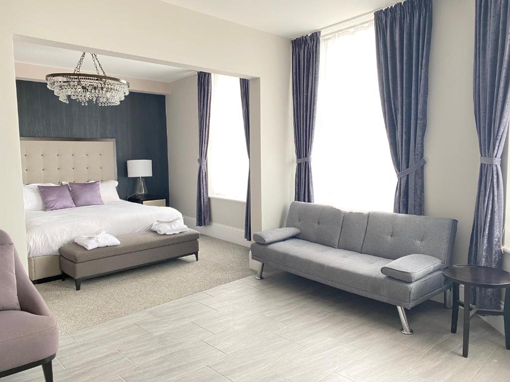 - une chambre avec un lit, un canapé et une chaise dans l'établissement The Royal Hotel - Clacton On Sea, à Clacton-on-Sea
