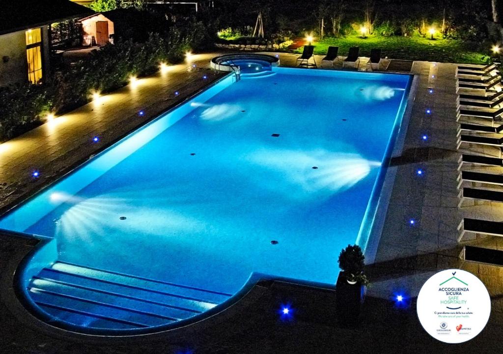 a large swimming pool with blue water at night at Hotel Victoria in Vicenza