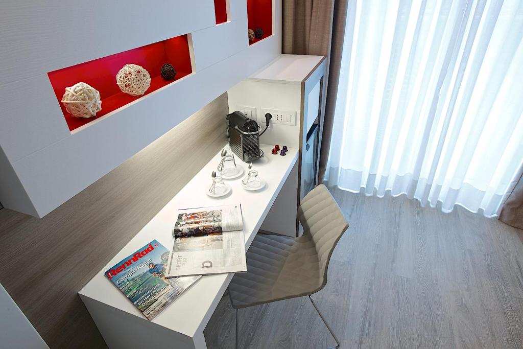 a room with a desk with a book and a chair at Enjoy Garda Hotel in Peschiera del Garda