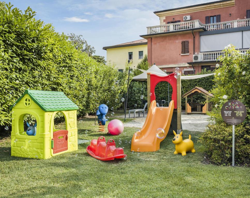 a group of childrens play equipment in the grass at Enjoy Garda Hotel in Peschiera del Garda