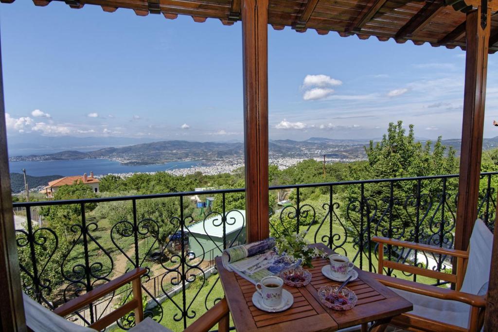 IATROU HOUSE- villa WITH INCREDIBLE VIEW في بورتاريا: طاولة على شرفة مطلة على المحيط