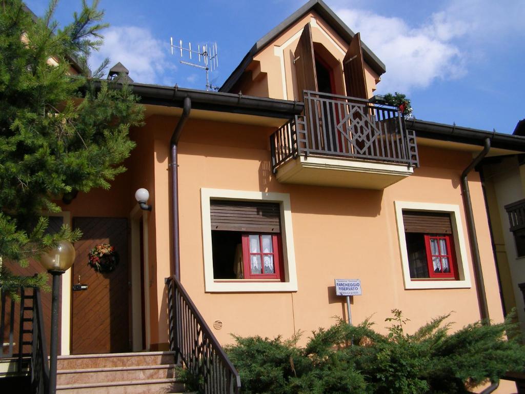 a house with a balcony and a staircase at Chalet Orchidea in Gallio