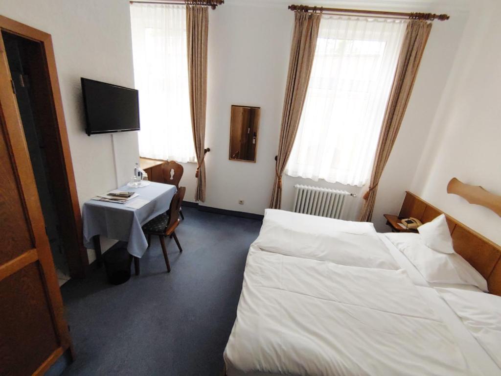 1 dormitorio con cama, escritorio y mesa en Berg´s Backpacker en Rüdesheim am Rhein