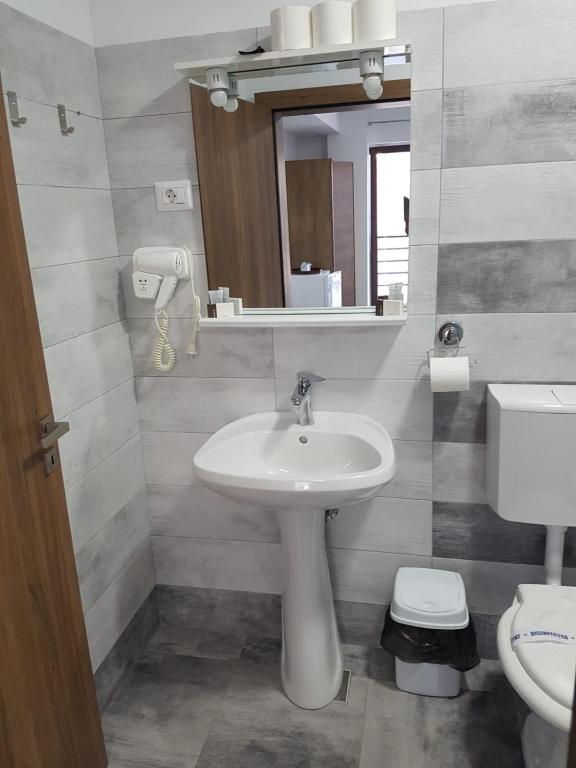 a bathroom with a sink and a toilet and a mirror at Vila La Matache in Eforie Nord