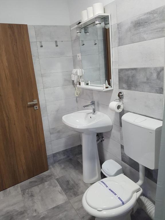 a bathroom with a white toilet and a sink at Vila La Matache in Eforie Nord